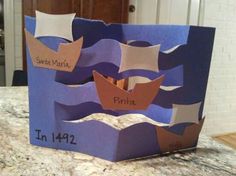 a paper boat made to look like it is sailing in the ocean with two names on it