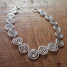 a silver necklace on a wooden table