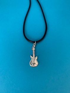 Silver guitar with either a black necklace chord (choose 17 or 19.5 inch at check out) or a Silver-plated 16, 28, or 20 inch snake chain that matches the silver guitar earrings on this page. Guitarists, bass players, and musicians love this item. Can be purchased as a set (see separate listing). Silver Rock Style Necklace Gift, Silver Rock Style Necklace As Gift, Silver Rock Style Necklace For Gift, Adjustable Music-themed Jewelry For Concerts, Nickel-free Music-themed Jewelry For Concerts, Guitar Earrings, Guitar Necklace, Silver Guitar, Bass Players