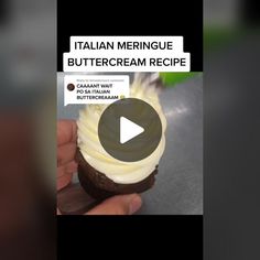 someone is holding a cupcake with cream frosting on it and the caption reads italian meringue buttercream recipe