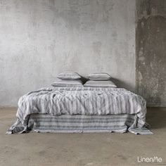 a bed sitting in the middle of a cement room