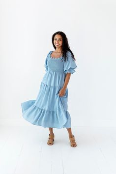 Features Square neck Elbow length elastic sleeve Smocked bodice Pockets Lined 97% Polyester, 3% Spandex Size + Fit Small 0-4, Medium 4-8, Large 8-12 Kristin is 5'4" a size 3 and is wearing a size Small True to size. Size Bust Length Small 41" Medium 41" Large 41" Flowy Smocked Puff Sleeve Dress For Daywear, Flowy Solid Smocked Dress With Smocked Back, Flowy Smocked Back Dress, Flowy Solid Smocked Dress, Casual Smocked Top With Square Neck And Elastic Sleeves, Casual Stretch Smocked Dress With Ruffles, Flowy Smocked Top With Puff Sleeves, Flowy Smocked Puff Sleeve Top, Spring Smocked Top With Smocked Bodice