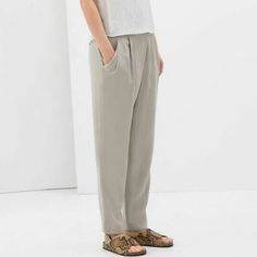 Zara Relaxed Draped Front Trousers In Sand.....Size S. Slinky Soft Weave; 100% Lyocell. Light Grayish Beige/Ivory/Stone. Crossover Draped Pleated Front. Elasticized Waistband At Back. Side Zipper Closure. Slanted Front Pockets. Relaxed Tapered Legs. Waist Across 14.25". Front Rise 10.75". Hip Across 20.75". Inseam 27.5". Leg Opening 6.25" Across. New With Tag. Gray High-waisted Pants For Spring, Spring Gray High-waisted Pants, Gray Straight Leg Summer Bottoms, Chic Gray Ankle-length Pants, Gray Summer Trousers, Summer Gray Trousers, Versatile Gray Relaxed Fit Bottoms, Relaxed Fit Gray Bottoms For Spring, Gray Relaxed Fit Bottoms For Spring