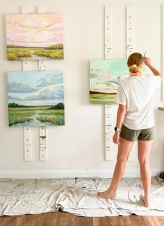 a woman is painting on the wall in her home