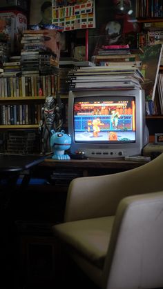 a small tv sitting on top of a wooden table in front of a bookshelf