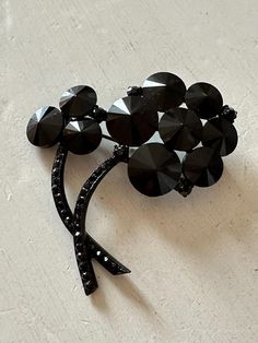 This listing is for a very unique and lovely vintage brooch by Weiss. It is 2 1/4" wide by 2 1/4" high with japanned metal, black rhinestone stems and flowers of rivoli stones. There is one tiny rhinestone missing from a stem (see Last Photo). The clasp is secure but note that the pin is bent - this does not affect closure. A unique and modern design! Albert Weiss designed exceptional jewelry in the United States from 1942-1971. This listing is for a very unique and lovely vintage brooch by Weis Vintage Black Pins For Gift, Vintage Black Pins As Gift, Vintage Black Pins For Gifts, Vintage Black Pins As Gifts, Antique Black Brooch For Evening, Antique Black Brooches For Evening, Antique Black Evening Brooch, Vintage Black Party Pins, Antique Black Brooch For Wedding