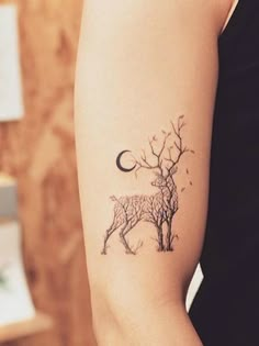 a woman's arm with a deer tattoo on it, and the moon in the background