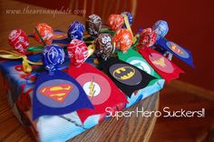 a table topped with lots of candy covered in batman and superman symbols on top of it