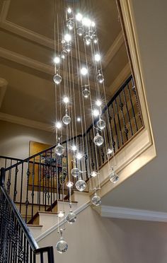 a chandelier hanging from the side of a staircase next to a banister