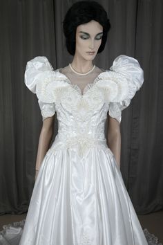 a mannequin wearing a white dress with ruffled sleeves