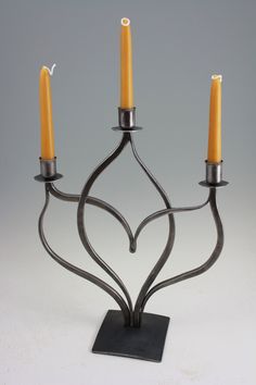 a metal candelabra with three candles on it