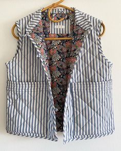 an apron hanging up on a wall with a flowered shirt and tie attached to it