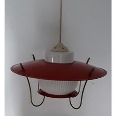 a red and white bird feeder hanging from a ceiling