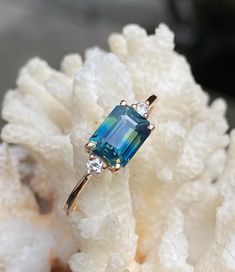 a blue ring sitting on top of a white rock