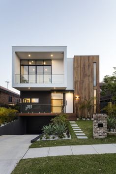 the modern house has two levels and is surrounded by greenery