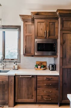 a kitchen with wooden cabinets and white counter tops, along with a window above the sink