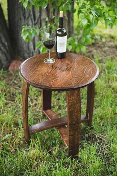 a wooden table with two wine glasses on it and a bottle of wine in the middle