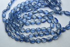 a blue glass bead necklace on a white surface