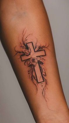 a cross tattoo on the arm