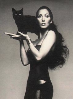 a woman holding a black cat in her arms and the caption reads instagram