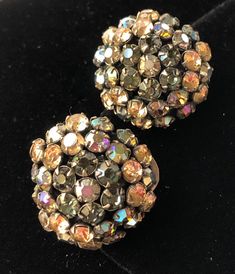 "Here is a lovely pair of vintage earrings by designer Schreiner of New York. The jewelry is beautifully designed with glittering faceted rhinestones in an enchanting color combination of topaz, green and aurora borealis hues. The setting is in gold tone metal and the earrings are in a clip on style. The earrings measure 1\" across. This jewelry is signed with the designer's hallmark on the back of one of the earrings. Noted is a slight difference between the round shape of each earring as well Evening Multi-stone Round Earrings, Dazzling Formal Clip-on Earrings With Sparkling Stones, Dazzling Clip-on Earrings With Sparkling Stones For Formal Events, Evening Round Crystal Earrings With Sparkling Stones, Sparkling Round Crystal Earrings For Evening, Dazzling Round Crystal Earrings For Evening, Evening Rhinestone Round Earrings, Rhinestone Round Earrings For Evening, Round Rhinestone Earrings For Evening