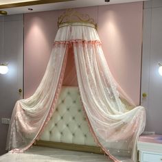 a pink and white canopy bed in a bedroom