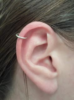 a close up of a persons ear with a single piece of metal in the middle