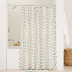 a bathroom with a white shower curtain and blue rug