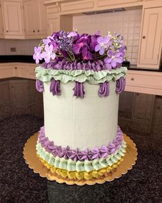 a white cake with purple flowers on top