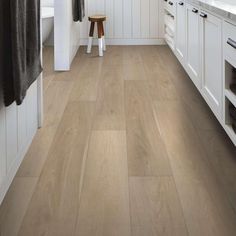 a kitchen with white cabinets and wood floors