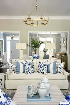 a living room filled with furniture and a chandelier hanging over the top of it