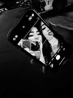 a person holding up a cell phone to take a selfie with the image of a woman's face