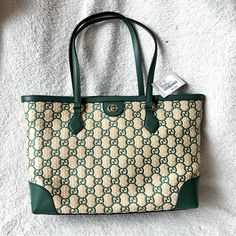 Typically Crafted In The Brand's Monogram Canvas, This Iteration Of Gucci's Famed Ophidia Tote Bag Feels Natural In Its Neutral Straw Construction With The Interlocking G Motif Woven In A Striking Green Hue. Outer: Straw 100%, Leather 100% Product Measurements Depth 5.5 In Handle 10 In Height 11 In Strap 21 In Width 15 In Made In Italy High-end Green Bags For Shopping, High-end Green Shopping Bag, High-end Green Tote Bag, Luxury Green Bags For Errands, Green Luxury Bag For Errands, Green Gucci Travel Bag, High-end Green Bags, Gucci Green Shoulder Bag For Daily Use, High-end Green Bags With Double Handle