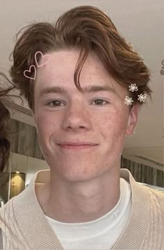 a young man is smiling at the camera and has two hair clips in his hair