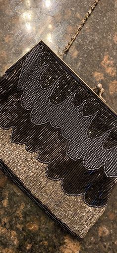 This beautiful vintage purse is in great used condition. It has an elegant beaded black and silver striking pattern to it.  Silver rope strap It has a working clasp and an inside pocket.  It measures 8 inches across on the bottom. It's 7 inches across on the top. It's 5 inches tall and one inch wide at the bottom. If you're looking to put a cell phone inside, Should not be larger than 6 1/2 inches long. The strap drops about 22 inches. Smoke free home    See other vintage items in my shop!! ALL Elegant Evening Bag With Beaded Fringe, Elegant Evening Bags With Beaded Fringe, Elegant Beaded Fringe Evening Bag For Formal Occasions, Beaded Fringe Evening Bag, Vintage Black Beaded Evening Bag, A Cell, Vintage Purse, Black And Silver, Clutch Purse