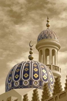 an ornate dome on top of a building with clouds in the sky behind it,