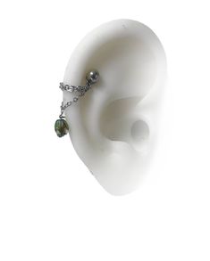 an ear with a chain attached to it and two beads hanging off the side of it