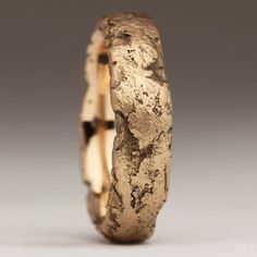 a close up of a gold ring on a white surface with cracks in the middle