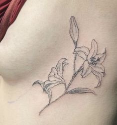 a woman's stomach with a flower tattoo on her left side ribcage