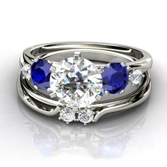 three stone engagement ring set with blue sapphires and diamonds in 18k white gold