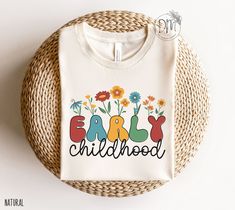 Introducing our Wildflowers Early Childhood Shirt, perfect for any member of the Early Childhood Squad! The beautiful floral design celebrates the joy of working with young children and is an ideal gift for any Daycare Teacher or Toddler Teacher. Made from high-quality materials, this shirt is both comfortable and durable, making it perfect for daily wear in the classroom. ✨ Please check the SIZE CHART image on the listing, and choose your size accordingly before placing your order.  🚫We do not Nana T Shirts, Gigi Shirts, Women Scientists, Nana Shirts, Science Shirts, Tech Shirt, Squad Shirt, Teacher Tees, Pregnancy Reveals