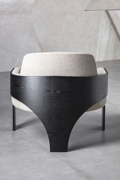 a black and white chair sitting on top of a cement floor