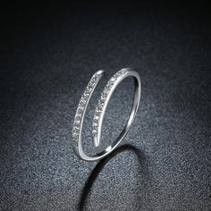 a diamond ring sitting on top of a black surface