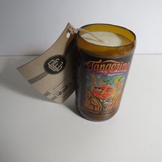 a candle with a tag on it sitting next to a paper bag that says fanggofum