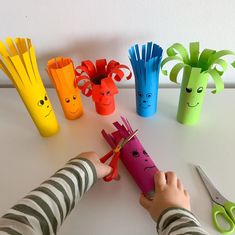 a child cutting out paper with scissors and other crafting items in front of them