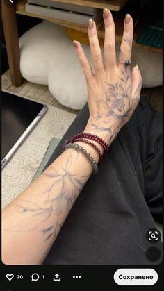 a woman's hand with tattoos on it and a laptop computer in the background