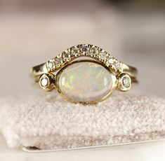 "Minimalist modern 14k yellow gold opal bezel setting ring.  10mm x 7mm oval cabochon genuine Ethiopian opal with 14k solid gold  band and bezel setting. 2 diamonds accented each side.Opal is October birthstone , 14th and 18th Anniversary gemstone. Opal is often associated with inspiration, passion and love. It's symbolizes faithfulness and confidence. Opal is associated with the Crown Chakra. THIS LISTING ONLY FOR OPAL DIAMOND RING. DETAILS ABOUT THE RING, MATERIAL AND STONES  Band is 14k yello Modern Oval Opal Ring In Yellow Gold, Modern Oval Yellow Gold Opal Ring, Modern Yellow Gold Oval Opal Ring, Modern Oval Opal Ring, Modern 14k Gold Oval Opal Ring, 14k Gold Oval Cabochon Opal Ring For Anniversary, Modern Oval Opal Ring With Bezel Setting, Anniversary Opal Ring With Bezel Set Oval Cabochon, Anniversary Opal Ring With Bezel Setting