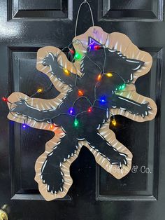 a door hanger decorated with christmas lights and an image of a cat on it