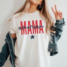 ORDER BY DECEMBER 10TH TO ENSURE CHRISTMAS DELIVERY.  ORDERS WILL STILL BE ACCEPTED AFTER THIS DATE, AND WILL BE PROCESSED AS SOON AS POSSIBLE, BUT MAY NOT ARRIVE BEFORE CHRISTMAS DAY.  PLEASE PLAN ACCORDINGLY AS REFUNDS WILL NOT BE PROVIDED FOR ORDERS THAT ARE DELIVERED WITHIN THIER ESTIMATED WINDOW.   Stay on trend this 4th of July with this American Mama Comfort Colors® t-shirt. The combination of stars, and the patriotic red/white/blue color scheme make this Independence Day tee perfect for White Americana Letter Print T-shirt, Americana Cotton T-shirt With Letter Print, American Style Cotton T-shirt With Short Sleeves, Red Americana T-shirt With American Flag, Casual Letter Print Tops For Veterans Day, Relaxed Fit Letter Print Tops For 4th Of July, White T-shirt With American Flag, American Style Pre-shrunk Cotton T-shirt, 4th Of July Cotton T-shirt With Text Print