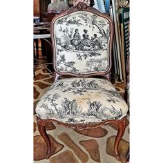 an antique chair is upholstered with black and white toiler print fabric